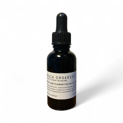 fruit and flower oil in black bottle on white background.